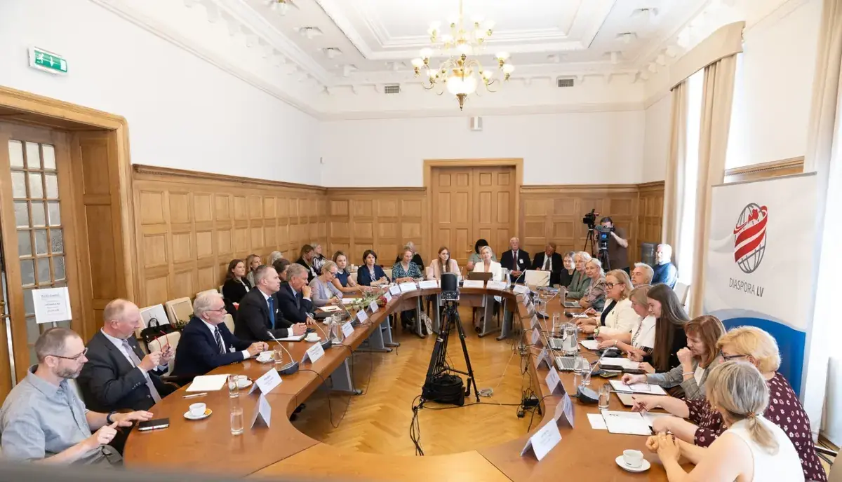 Diasporas konsultatīvās padomes sēde — dalībnieki pie apaļā galda zālē ar DIASPORA LV baneri