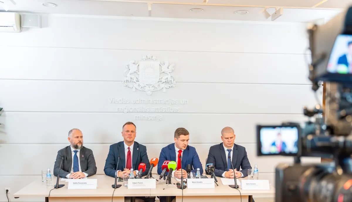 Preses konference VARAM: pie galda sēž Valdis Pusvācietis, Edgars Tavars, Māris Zviedris un Varis Teivāns, priekšplānā videokamera